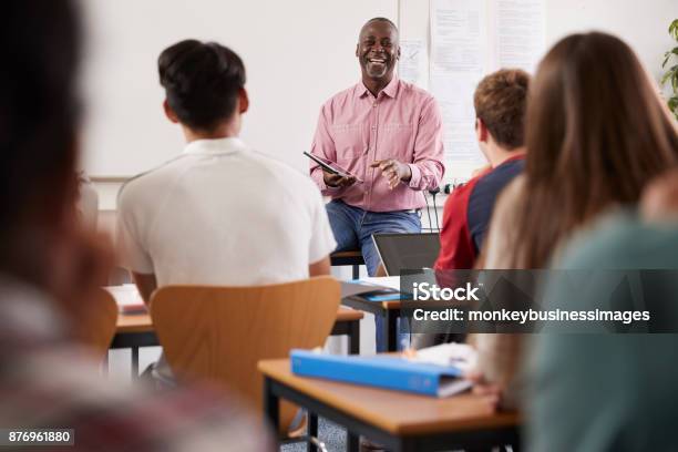 Male College Tutor With Digital Tablet Teaching Class Stock Photo - Download Image Now