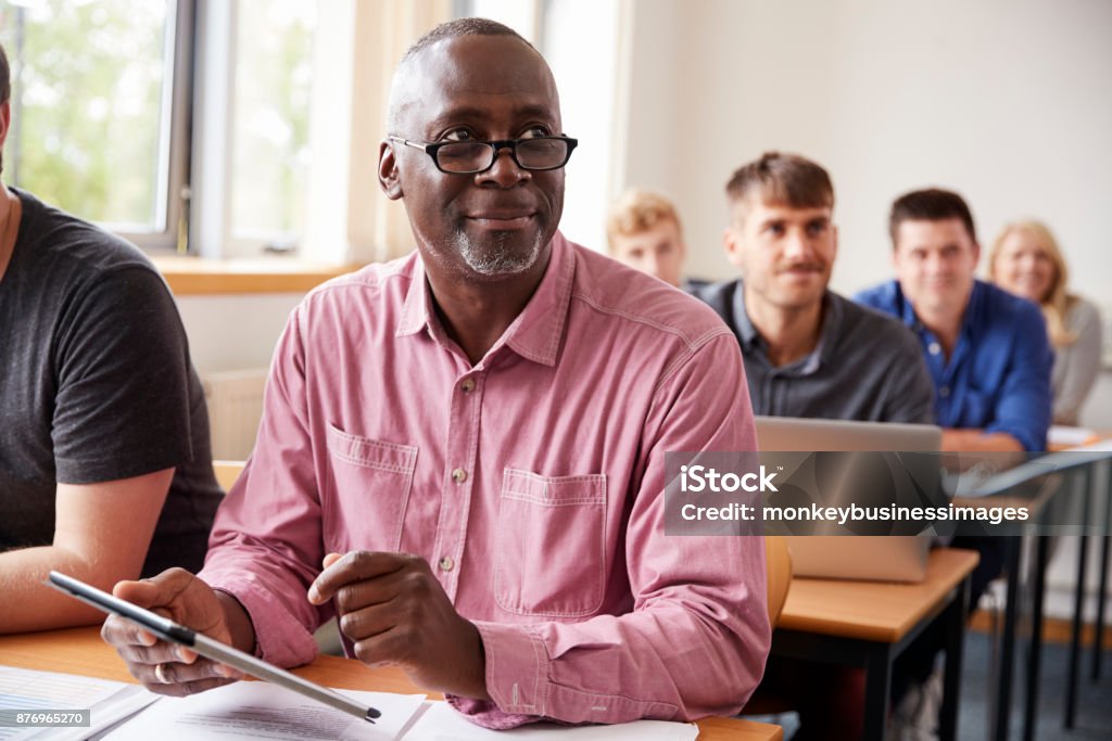 Étudiant à l’aide de tablette numérique dans l’éducation des adultes classe de maturité - Photo de Troisième âge libre de droits