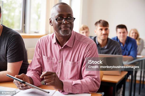 Photo libre de droit de Étudiant À Laide De Tablette Numérique Dans Léducation Des Adultes Classe De Maturité banque d'images et plus d'images libres de droit de Troisième âge