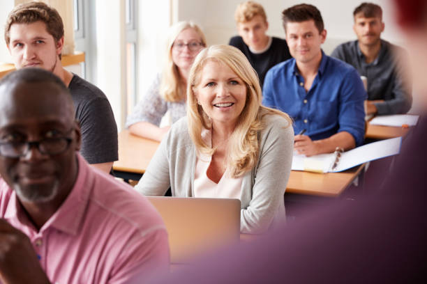 istock Male Tutor Teaching Class Of Mature Students Viewed From Behind 876965516