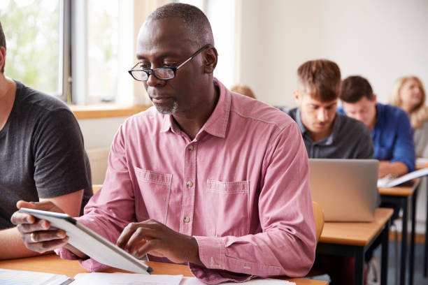 istock Mature Student Using Digital Tablet In Adult Education Class 876965518