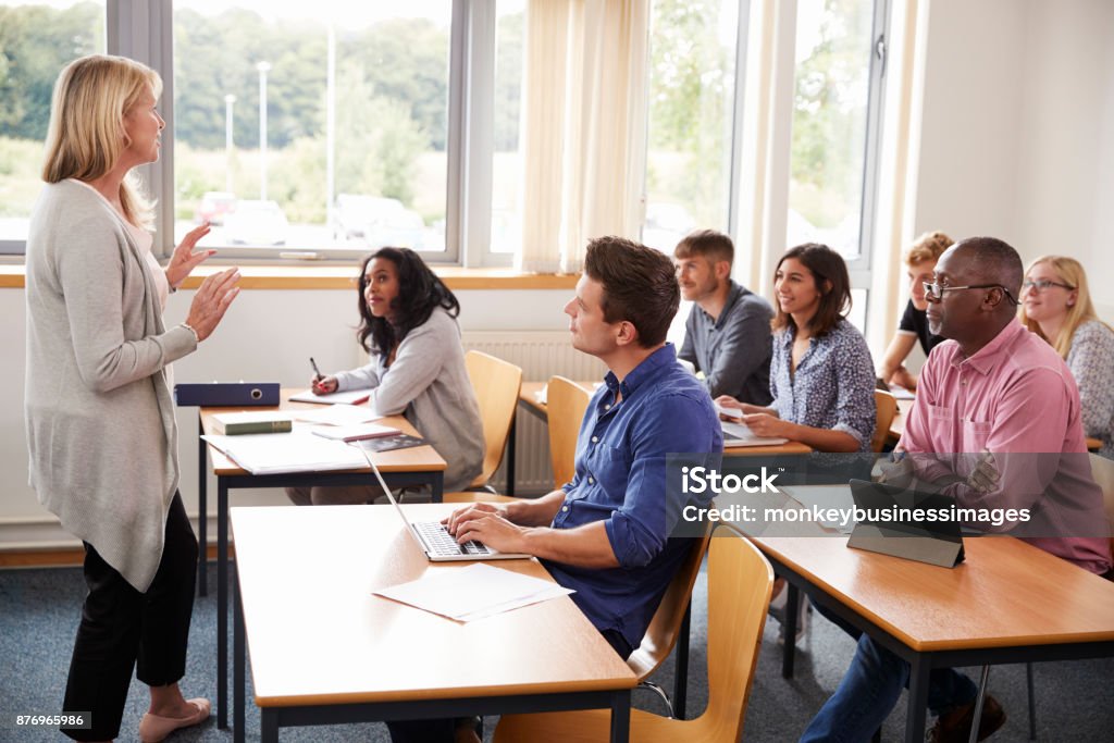 Female Tutor Teaching Class Of Mature Students Classroom Stock Photo
