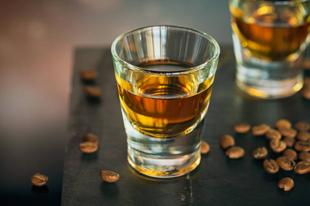 istock Cognac or liqueur, coffee beans and spices on a glass table. 876966084