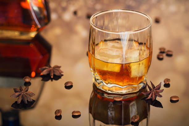 istock Cognac or liqueur, coffee beans and spices on a glass table. 876966086