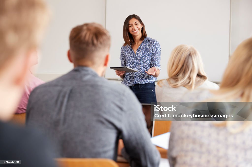 Tutor de Universidad con tableta Digital enseña a los estudiantes maduros - Foto de stock de Adulto libre de derechos