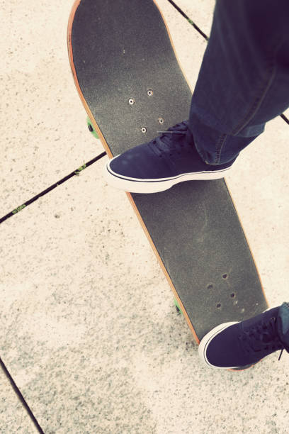 istock Skateboarder legs riding skateboard on city 876966540