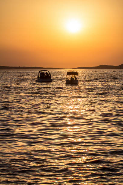 istock Sunset over sea with boats 876966552