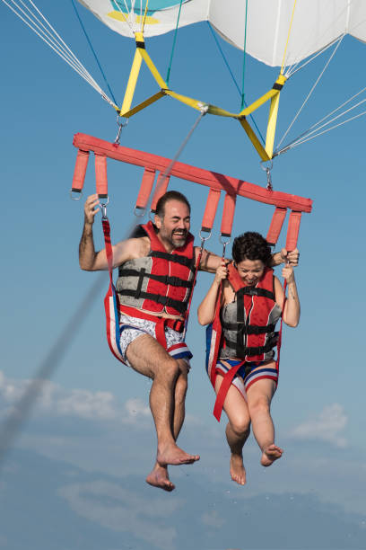 istock Lovely couple during  parasailing 876970892