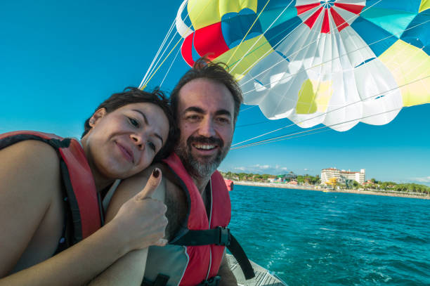 Lovely couple before parasailing Lovely couple before parasailing parasailing stock pictures, royalty-free photos & images