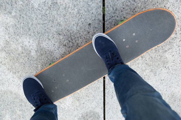 istock Skateboarder legs riding skateboard on city 876978362