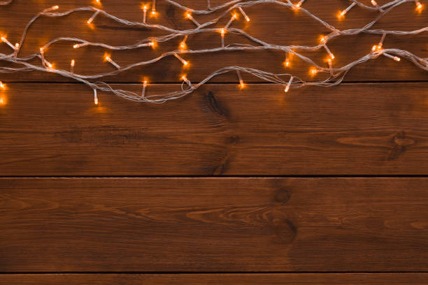 istock Christmas lights border on wood background 876978762