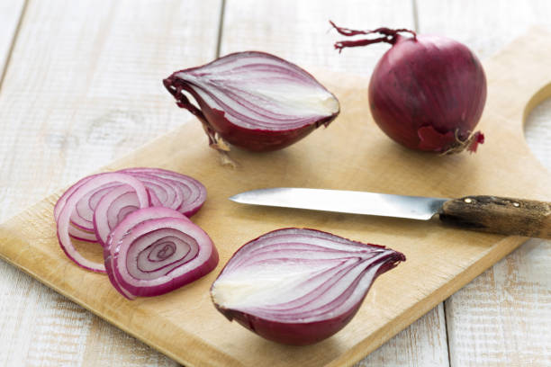 istock Sliced red onions on a cutting board with a knife 876978926