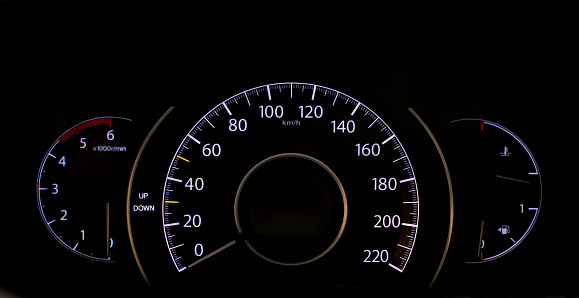 Isolated speedometer with white lights on black background