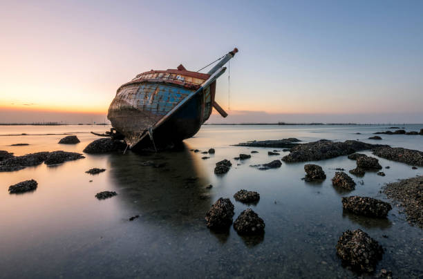 bellissimo tramonto, barca si schianta nel mare, paesaggio thailandia - storm sailing ship sea shipwreck foto e immagini stock