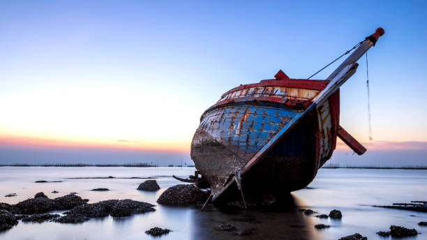 bellissimo tramonto, barca si schianta nel mare, paesaggio thailandia - storm sailing ship sea shipwreck foto e immagini stock