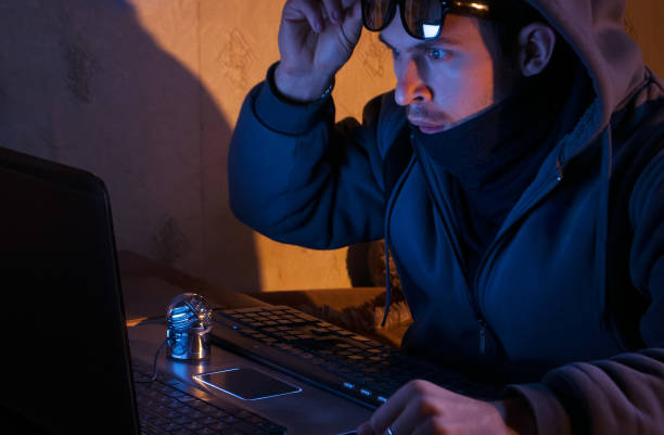 istock surprised hacker looks at the laptop, the intruder breaks into a system, 876989740