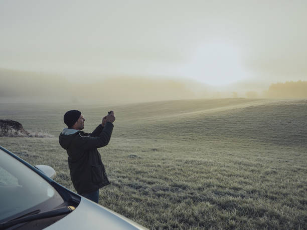 istock Man out with his car in winter nature landscape 876998814