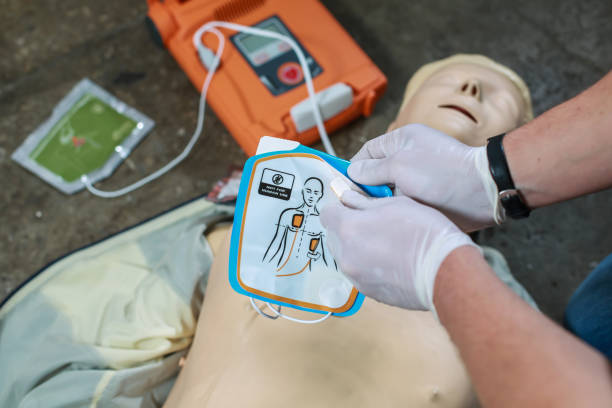 AED (3) The use of an automatic external defibrillator in conducting a basic cardiopulmonary resuscitation to the victim on the street defibrillator photos stock pictures, royalty-free photos & images
