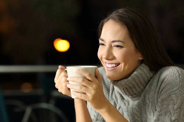 istock Happy girl drinking coffe in the night 877002970