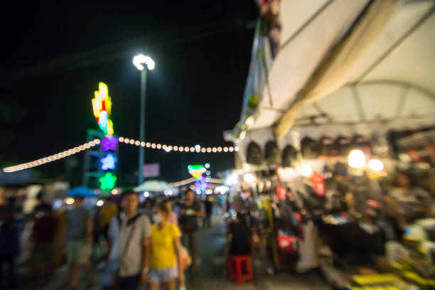 istock Blurred image of people walking in market at night 877006120