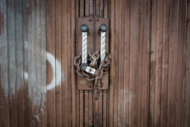 istock Padlock and chain locked securely on factory door. 877014874