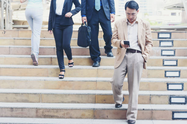 istock Professional man using smart phone,Businessman holding mobile smartphone using app texting sms message, checking email and social media while walking in the city. 877018476