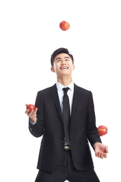 young asian businessman juggling three apples