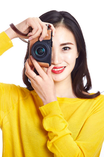 young asian woman taking a picture with camera, isolated on white background.