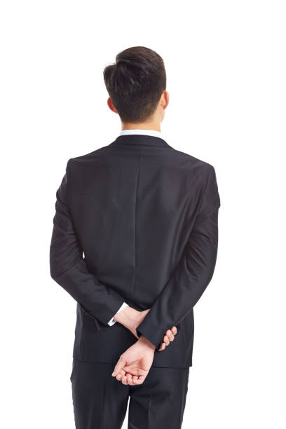 rear view of a thinking asian business man rear view of a contemplating young asian businessman, studio shot, isolated on white background. hands behind back stock pictures, royalty-free photos & images