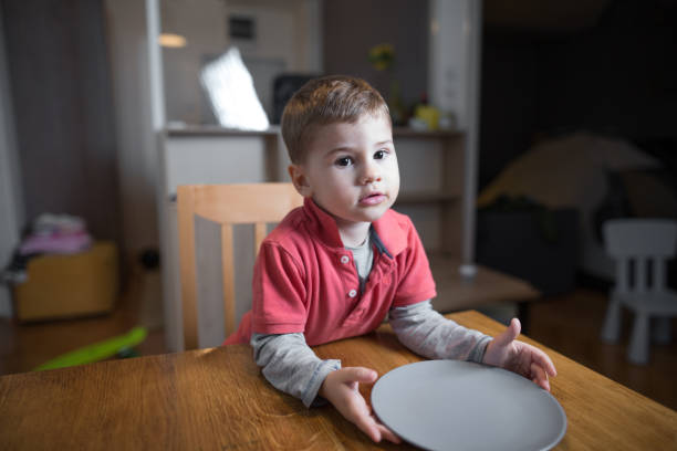 petit garçon attend son dîner - avoir faim photos et images de collection