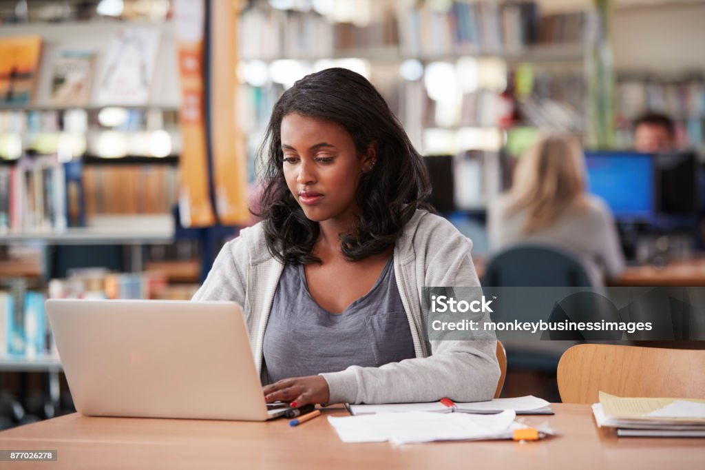 Mature Female Student Working On Laptop In College Library University Student Stock Photo