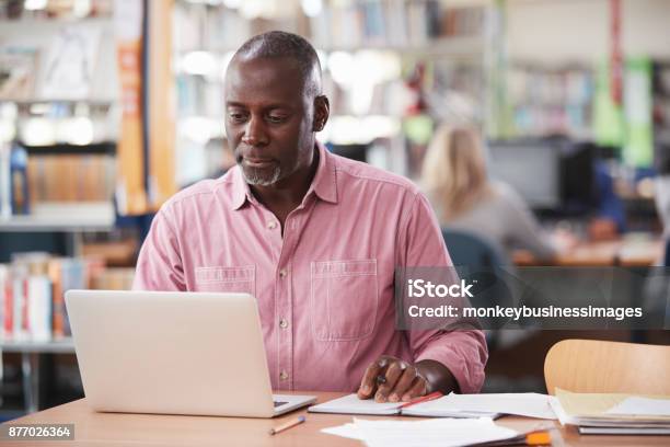 Mature Male Student Working On Laptop In College Library Stock Photo - Download Image Now