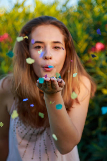 istock Young woman blowing confetti 877026804