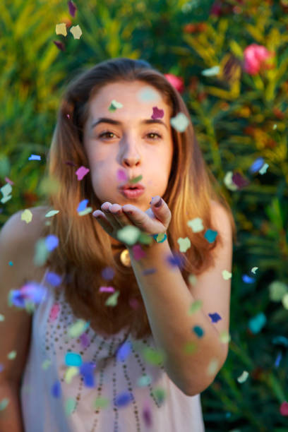 istock Young woman blowing confetti 877026812