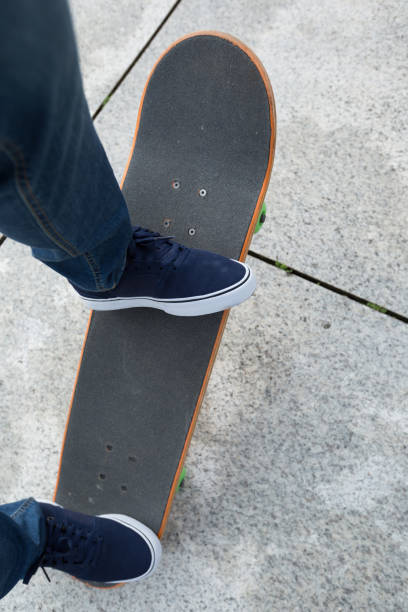 istock Skateboarder legs riding skateboard on city 877027170