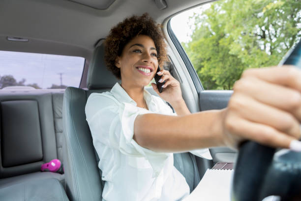 istock Pretty African American woman uses smart phone while driving 877029716