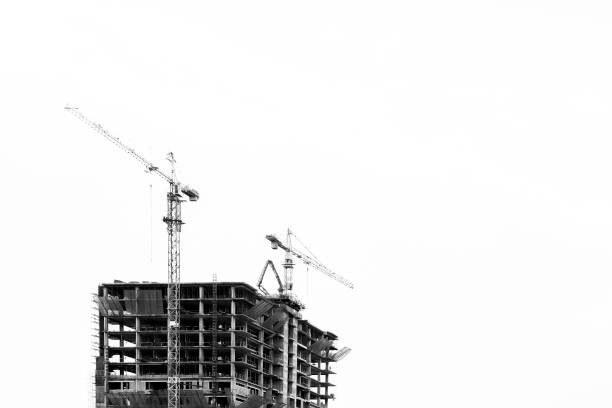 istock Industrial construction cranes and building black and white insolated.Industrial construction crane over building site 877029746