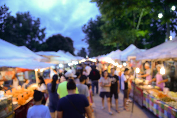 タイ バンコクのストリート マーケットを歩いての背景をぼかし。週末のショッピングのためのローカルのストリート マーケットで歩く観光客 - 夜市 ストックフォトと画像