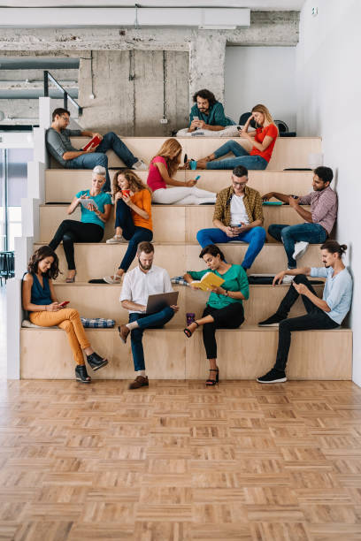 istock Large group of people in different activities in a loft office 877030110
