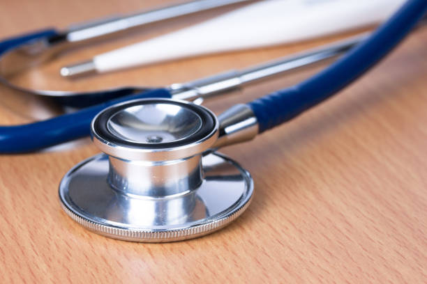 istock Stethoscope with mercury on wooden table 877030522