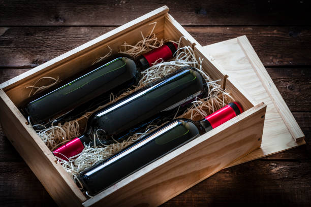 istock Red wine bottles packed in a wooden box shot rustic wooden table 877031344