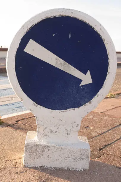White arrow on old and blue traffic sign - traffic sense
