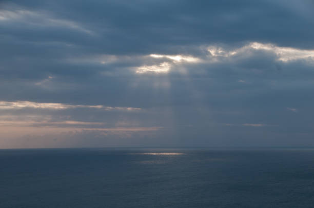 istock Heaven sun light shading from cloudy sky to the ocean 877037664