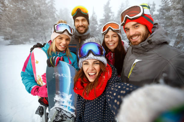 inverno, sport estremo e concetto di persone - amici che si divertono sulla neve e fanno selfie - skiing ski family friendship foto e immagini stock