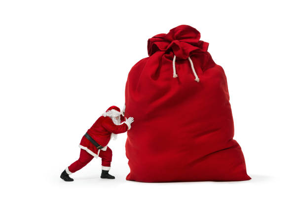 babbo natale spinge un enorme sacchetto di regali di natale - santa claus bag sack christmas foto e immagini stock