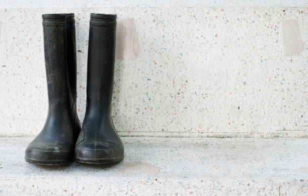 istock Black rain boots on marble garden bench 877043724