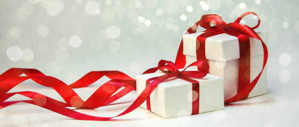 istock Christmas Gift in White Box with Red Ribbon on Light Background. New Year Holiday Composition. Copy Space For Your Text 877048170