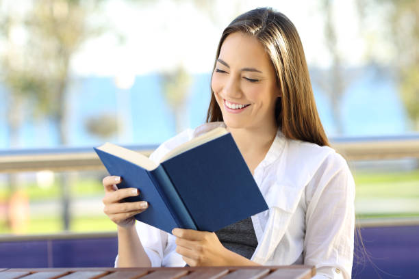 istock Woman reading a book during vacations on the beach 877053072