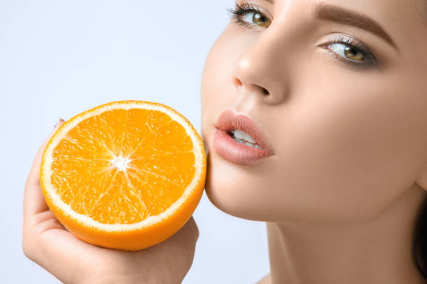 istock Beautiful woman's face with juicy orange 877057102