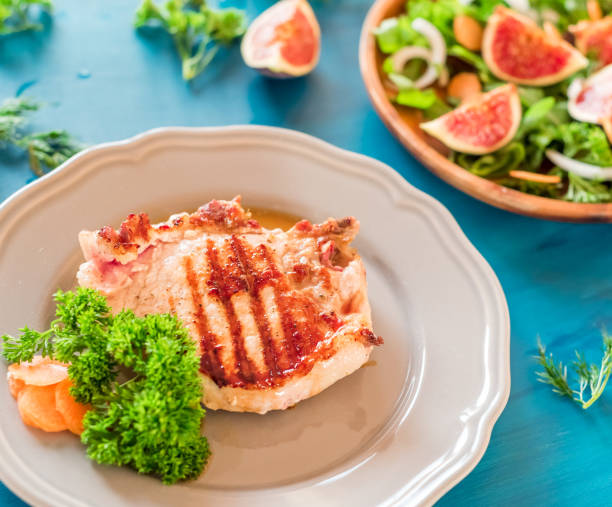 istock Grilled steaks on a gray plate blue background 877057536